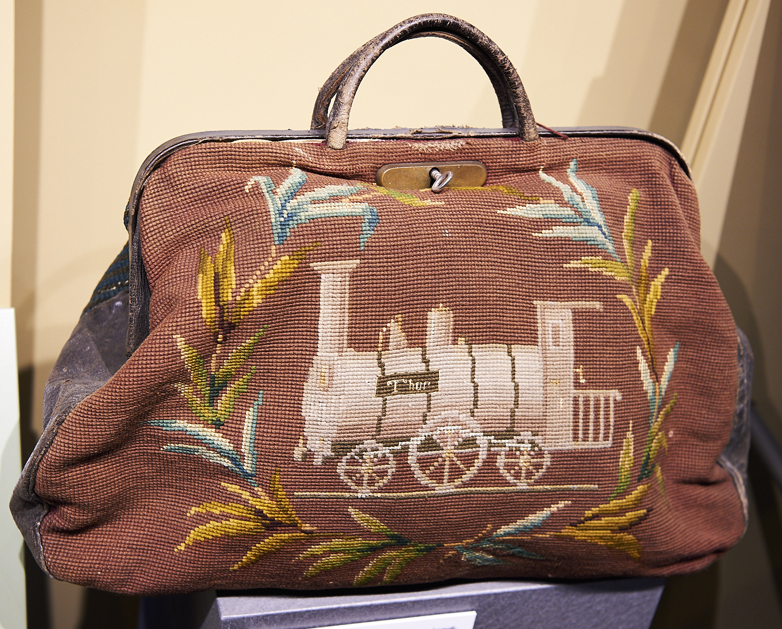 A beautiful carpet bag with an embroidered steam engine 